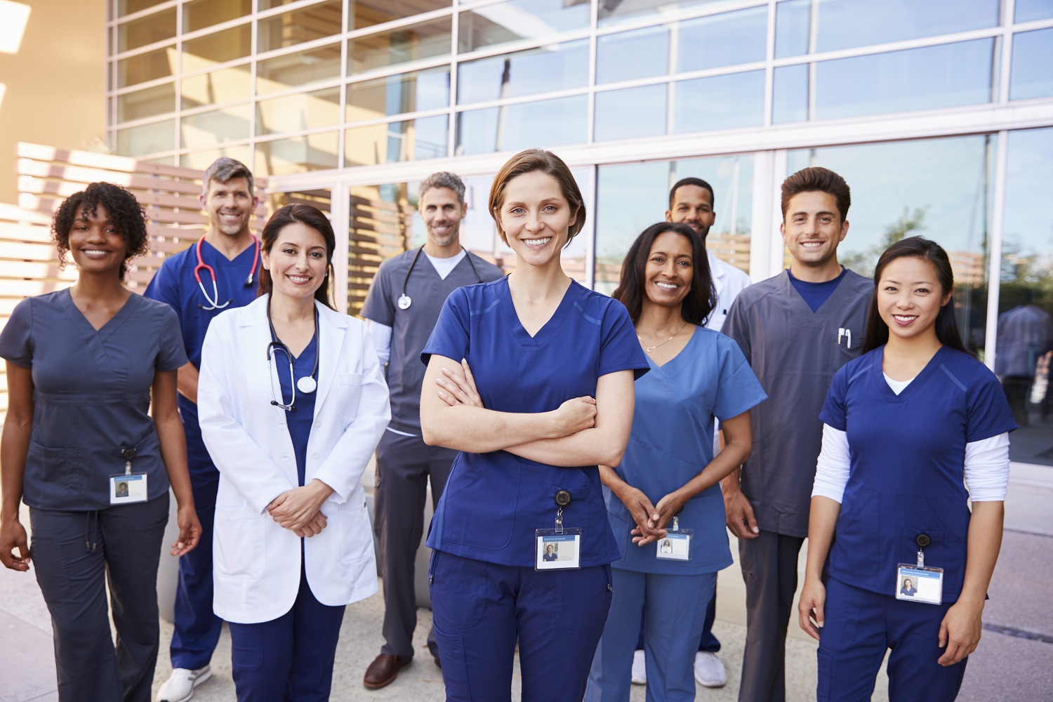 Team of healthcare workers with ID badges outside hospital